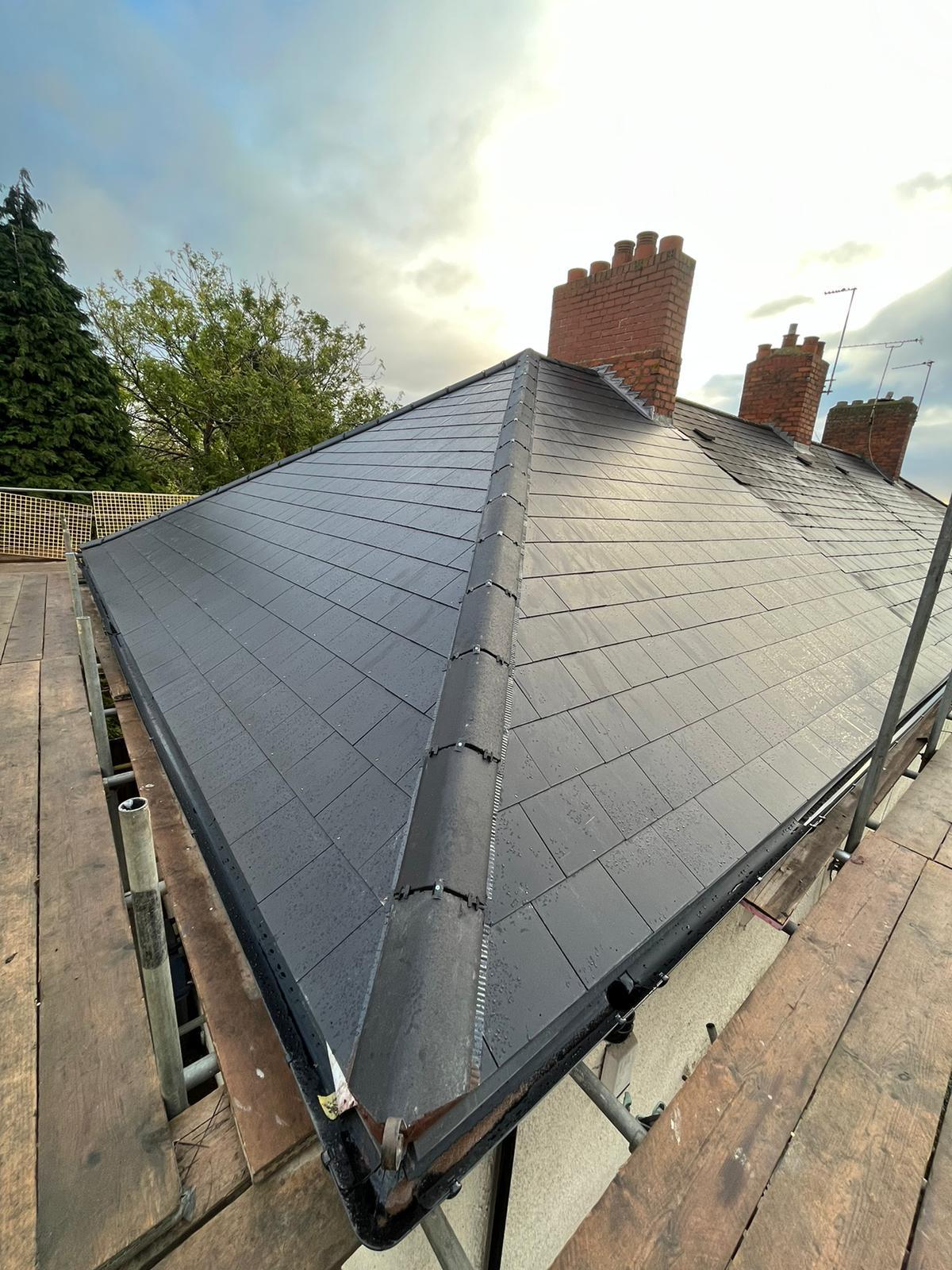 New grey slate hipped roof installation with chimney stack, completed by UK Roofing and Improvements Ltd