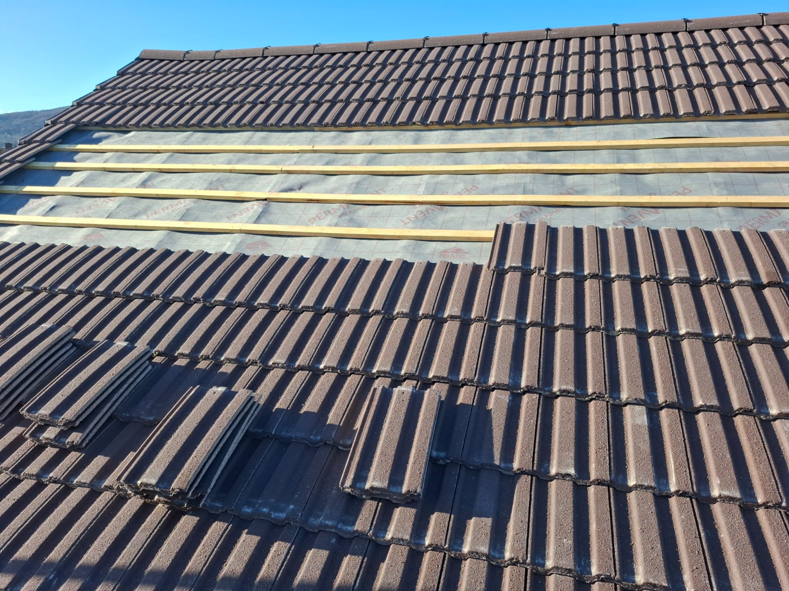 Brown concrete tile re-roof in progress with breathable membrane and new battens